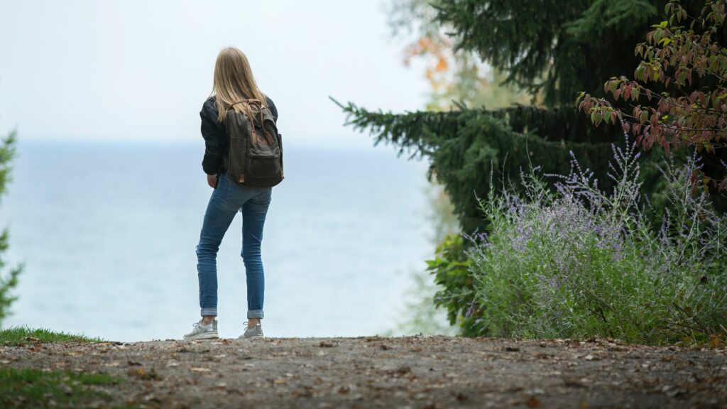 Jeune femme avec un sac à dos qui prend une marche en nature. 