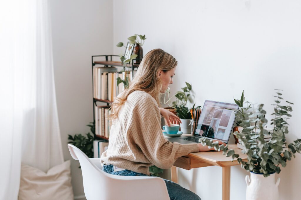 Jeune femme blonde qui fait le tri de ses photos numériques dans son bureau