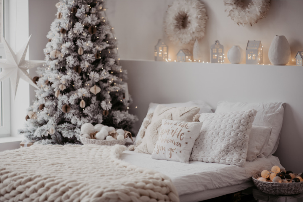 Décorations de Noël. Décor de chambre avec un couvre-lit et un sapin blanc.