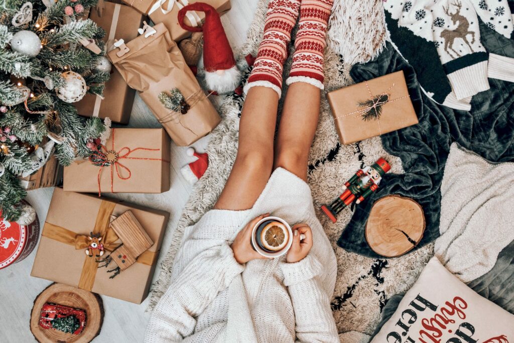 Une femme est assise au beau milieu des cadeaux de Noël qu'elle a enveloppés.