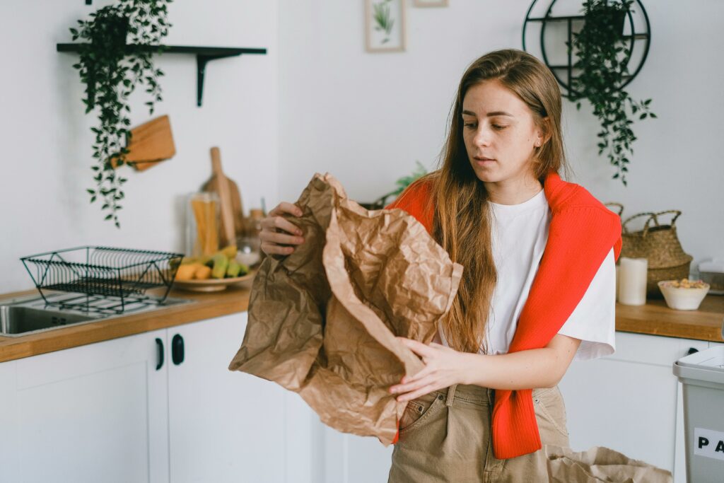 Une jeune femme aux cheveux longs et châtains fait le tri et prends conscience de l'encombrement chez elle. 