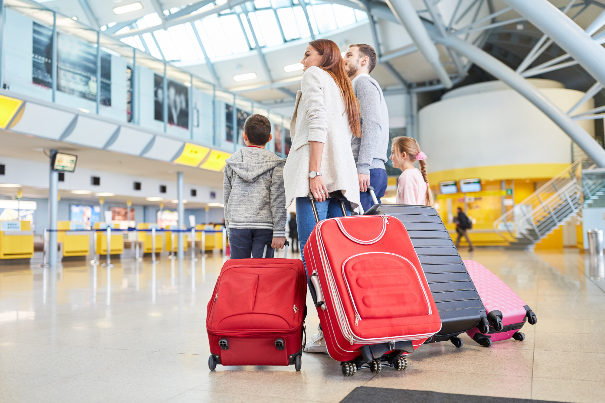 Une famille de 4 membres à l'aéroport avec leurs valises