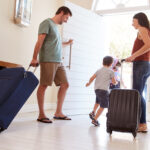 Une famille souriante quitte la maison avec des valises, illustrant les conseils de StéZen pour bien préparer sa maison avant les vacances et partir l’esprit tranquille.