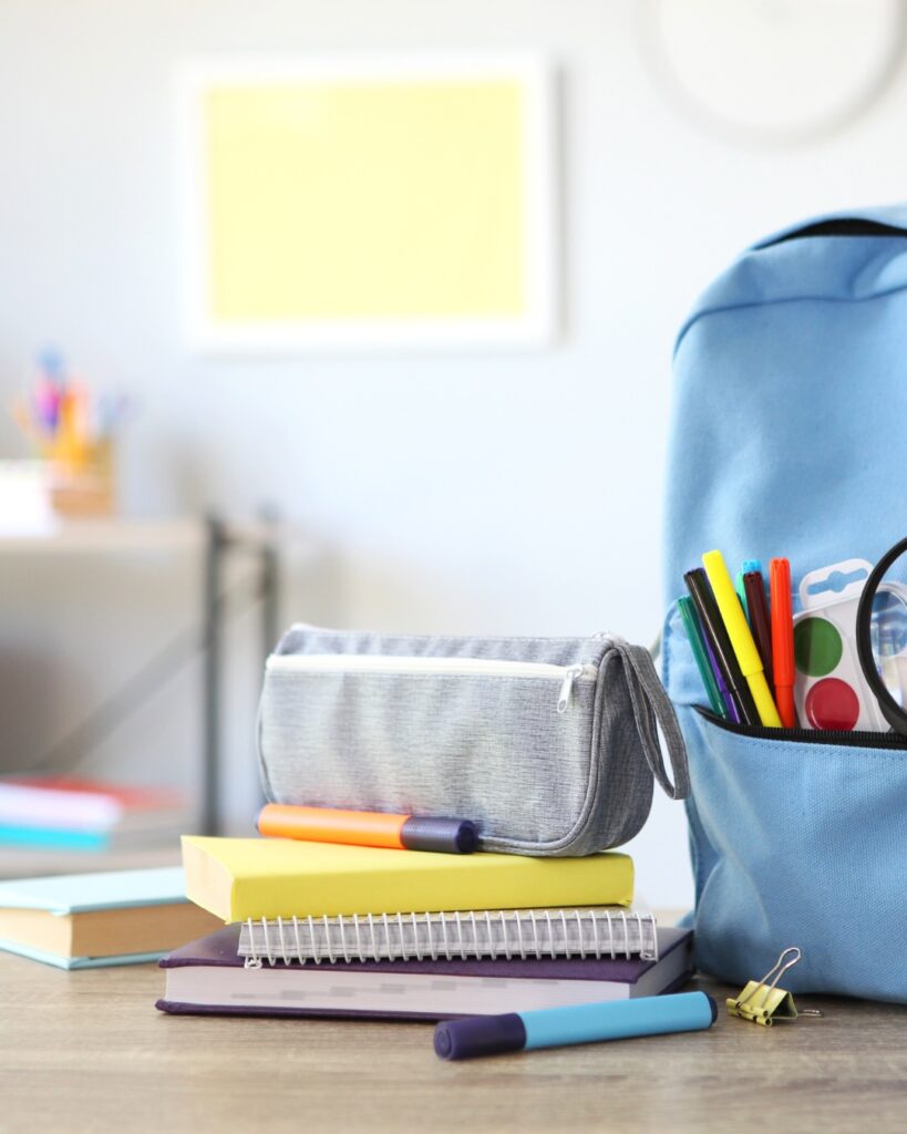 Fournitures scolaires et sac bien préparé sur une table: tout est prêt pour une rentrée scolaire organisée et sans stress.