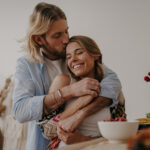 Couple partageant un moment de complicité dans un espace lumineux et épuré, illustrant comment désencombrer la maison peut contribuer à une relation plus harmonieuse et apaisée.