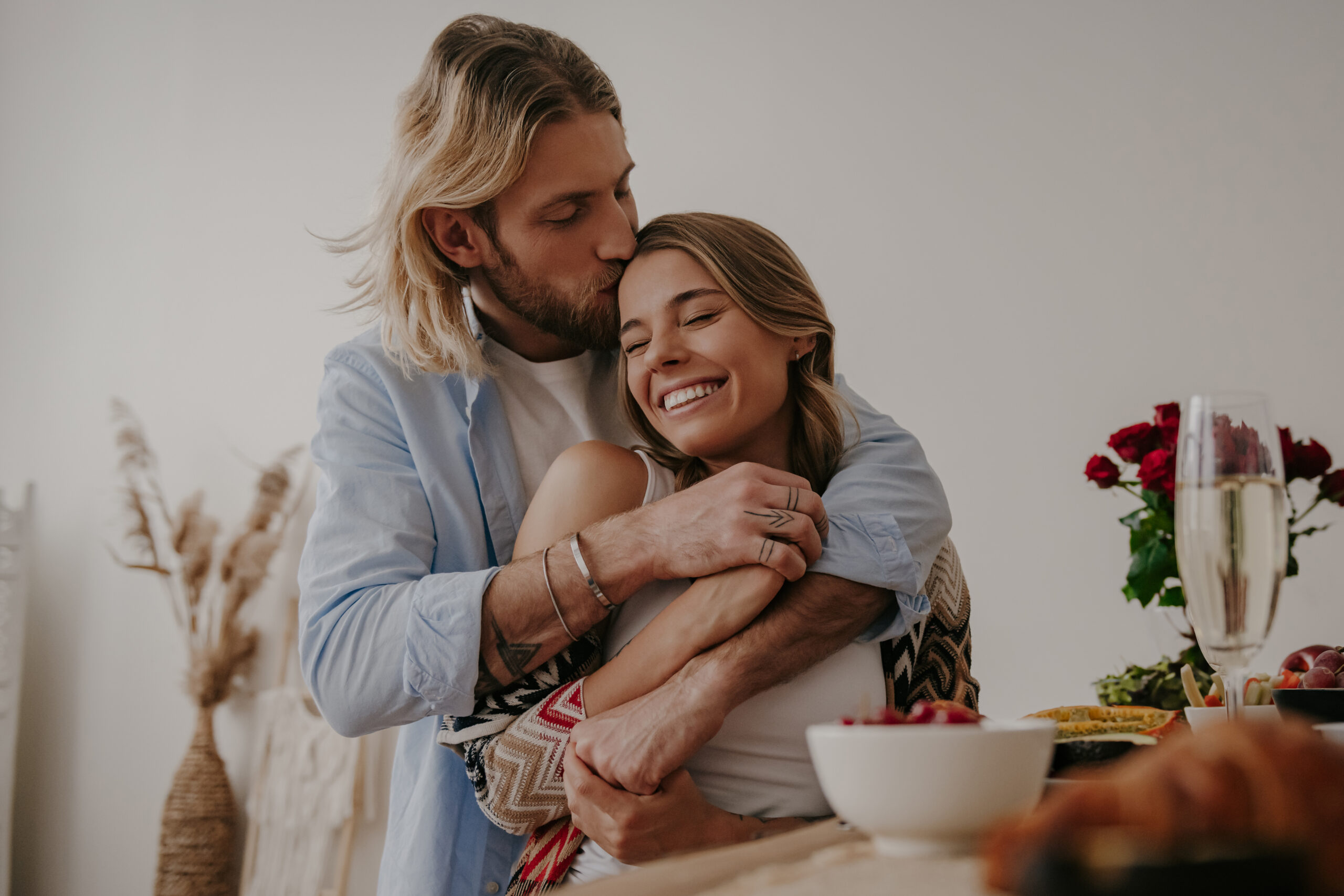 Couple partageant un moment de complicité dans un espace lumineux et épuré, illustrant comment désencombrer la maison peut contribuer à une relation plus harmonieuse et apaisée.