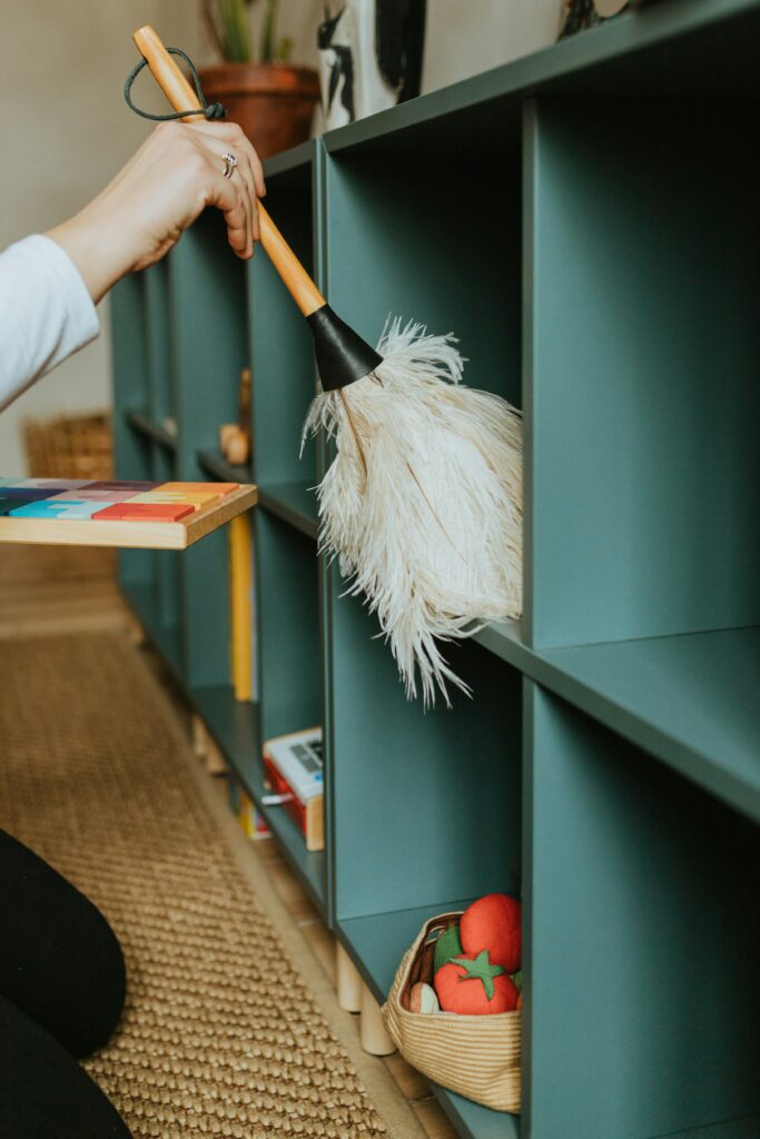 Nettoyage et organisation d’une étagère de rangement avant de replacer les objets dans un espace bien structuré.