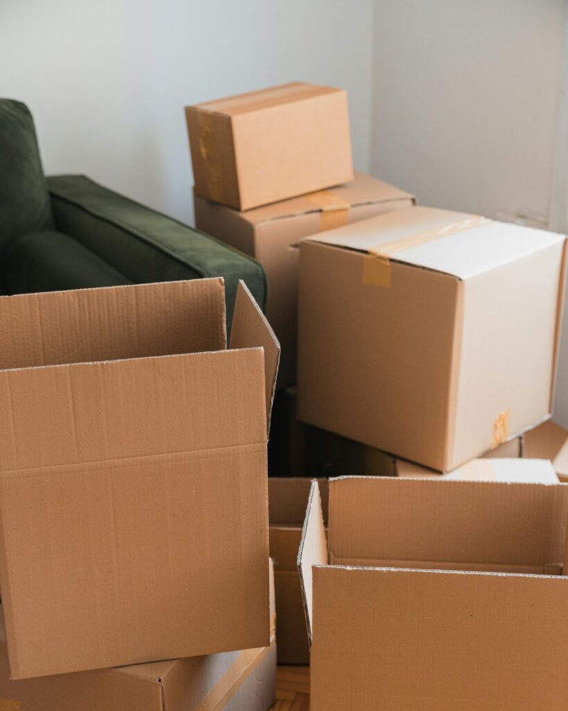 Boîtes de déménagement empilées dans un salon, illustrant l'organisation lors d'une période de transition et la préparation d'un nouveau départ.