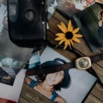 Vieilles photographies, montre, appareil photo et objets souvenirs disposés sur une table en bois, représentant l'attachement aux objets, les souvenirs de famille et les moments précieux qui marquent une vie.