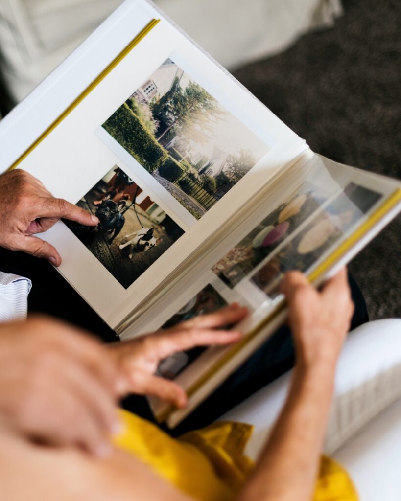 Proches feuilletant ensemble un album de photos et partageant des souvenirs de famille.