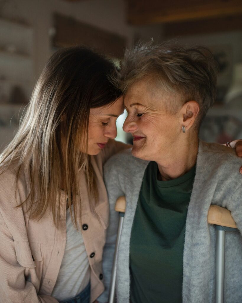 Femme partageant un moment de complicité avec une proche plus âgée à la maison.