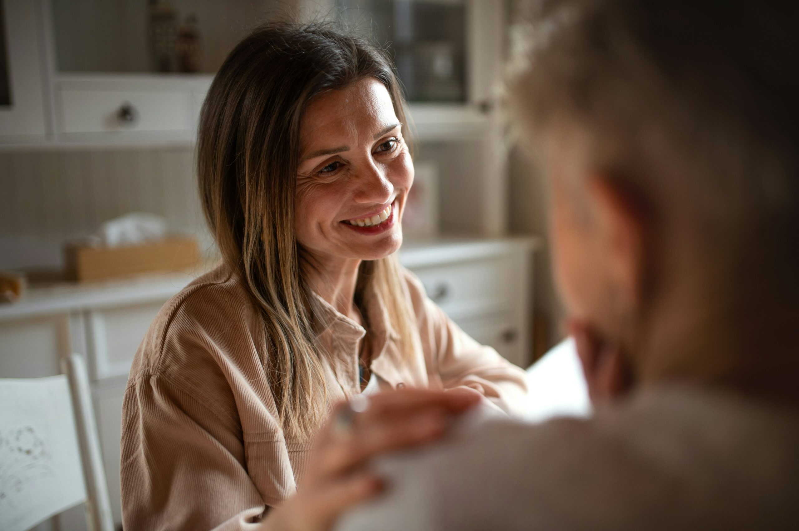 Femme discutant avec un proche à la maison dans le cadre de la préparation de sa succession et du désencombrement.